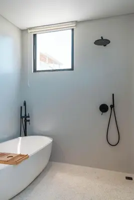 a white bathroom with a tub and a window at Berawa Breeze - Chic 4BR Beachside Oasis with Sauna in Canggu
