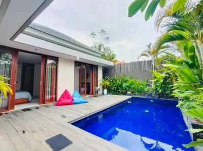 a villa with a swimming pool and a house at Cosy Haven 2 BR Villa in Umalas in Canggu