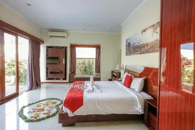 a bedroom with a large bed with a red blanket at 1 Bed Room Villa In Seminyak in Seminyak