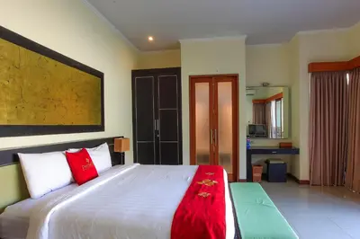a bedroom with a large white bed with red pillows at 1 Bed Room Villa In Seminyak in Seminyak
