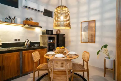 a kitchen with a table and chairs and a kitchen with a sink at Alaya Homes A - Luxury Japandi Loft Suite in Seminyak in Seminyak