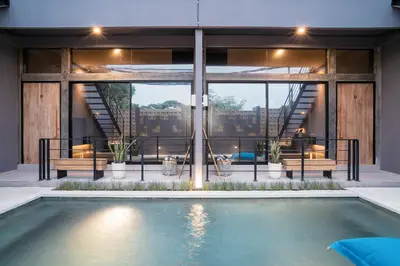a house with a swimming pool in front of a building at Alaya Homes A - Luxury Japandi Loft Suite in Seminyak in Seminyak