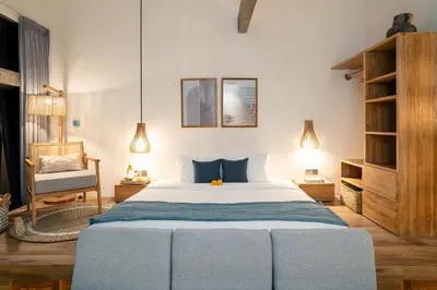 a bedroom with a large bed and a chair at Alaya Homes C - Elegant Japandi Loft Suite in Seminyak in Seminyak