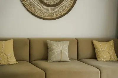 a couch with two pillows and a mirror on the wall at Premier Umalas Villas in Seminyak