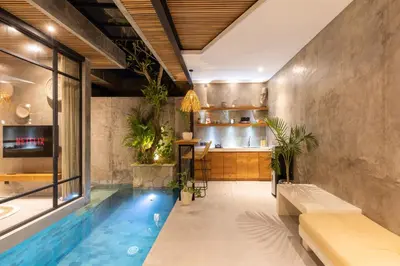 a room with a pool and a bar with plants at 10 mins to beach - BRAND NEW 1 BD w/Pool + Netflix in Canggu