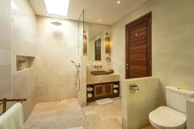 a bathroom with a shower and a toilet and a sink at Villa Tiga Puluh, 7 Bedrooms Private Villa in Seminyak in Seminyak