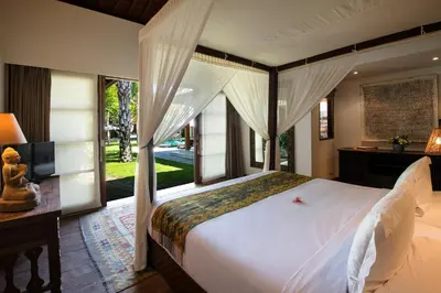 a bedroom with a large bed and a large window at Villa Tiga Puluh, 7 Bedrooms Private Villa in Seminyak in Seminyak