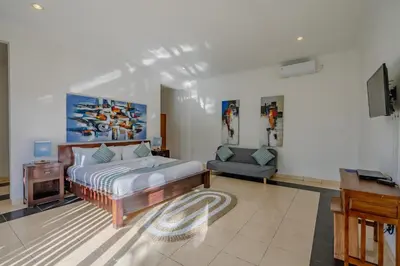 a bedroom with a bed and a tv and a couch at Villa Alleira - 5 Bedroom Villa in Centre Location of Seminyak in Seminyak