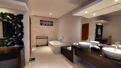 a bathroom with two sinks and a large mirror at The Light Exclusive Villas and SPA in Seminyak