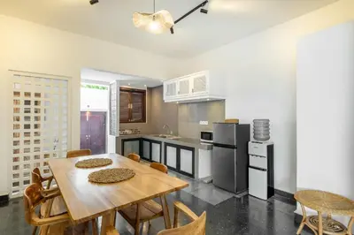 a kitchen with a wooden table and chairs at LaLeBay Villa Seminyak in Seminyak