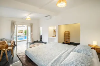 a bedroom with a large bed and a dining room at LaLeBay Villa Seminyak in Seminyak