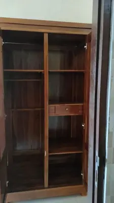 a wooden book shelf in a room at Bali Holiday Guesthouse near IALF & Benoa in Pesanggaran