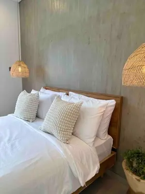 a white bed with white pillows and a lamp at Villa Efire-3 bedroom with pool in Seminyak