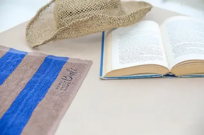 a hat and an open book on a table at Villa Isea-3 bedroom with pool in Seminyak