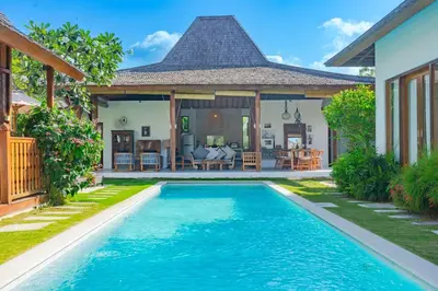 a villa with a swimming pool in front of a house at Milavila in Seminyak