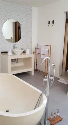 a bathroom with a tub and a sink and a mirror at Milavila in Seminyak