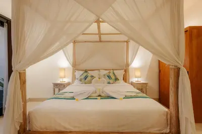 a bedroom with a canopy bed with two lamps at Villa Sri, Seminyak - 3 Bedroom Stylish Pool Villa! in Seminyak