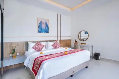 a bedroom with a large bed with red and white pillows at Villa Marili Seminyak by Nagisa Bali in Seminyak