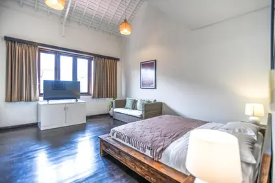 a bedroom with a bed and a flat screen tv at Melo Suites Hotel in Seminyak