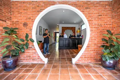 a man standing in front of a brick wall with a mirror at Melo Suites Hotel in Seminyak