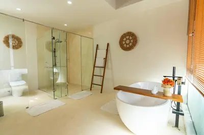 a bathroom with a bath tub and a shower at Green Jimbaran Bay Villa II in Jimbaran