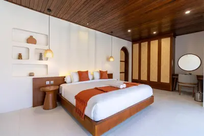a bedroom with a large bed and a table at Green Jimbaran Bay Villa II in Jimbaran