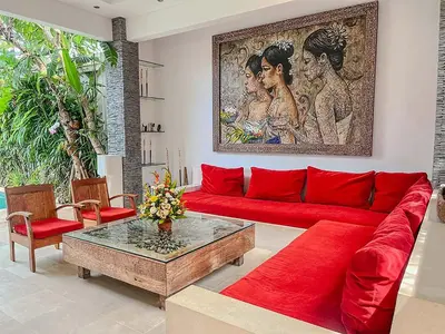 a living room with a red couch and a table at Villa Kallayaan by Optimum Bali Villas in Seminyak