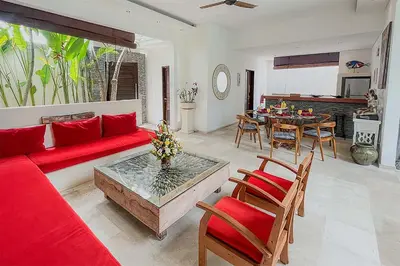 a living room with a red couch and a table at Villa Kallayaan by Optimum Bali Villas in Seminyak