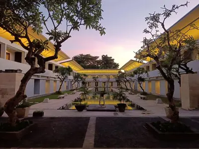 a courtyard with trees in front of a building at Kuta Living by Kamara in Kuta