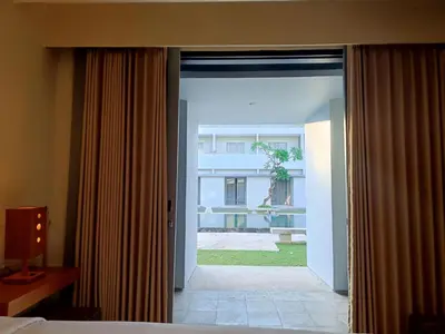 an open door to a bedroom with a view of a building at Kuta Living by Kamara in Kuta