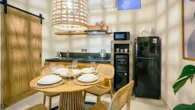 a kitchen with a table with chairs and a refrigerator at Alaya Homes D - Chic Japandi Loft Suite in Seminyak in Seminyak