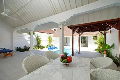 a patio with a table and chairs and a pool at Villa Ley Charming 2 Bedroom Villa Seminyak Private Pool in Seminyak