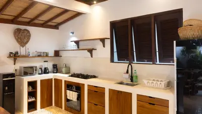 a kitchen with wooden cabinets and a counter top at Villa Arev in Kerobokan