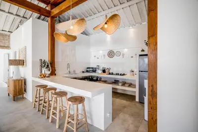 a kitchen with a large white counter and stools at Villa Passion by Alfred in Bali in Seminyak
