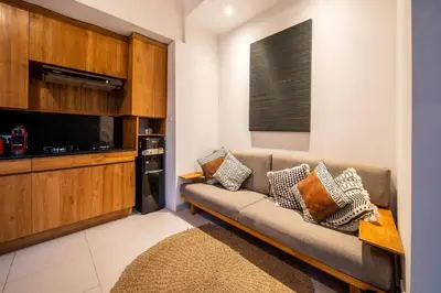 a living room with a couch and a kitchen at Villa Banua 3 Seminyak in Seminyak