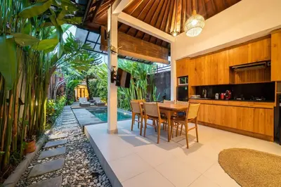 an open kitchen and dining room with a table and chairs at Villa Banua 3 Seminyak in Seminyak