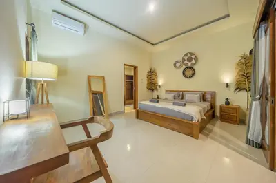 a bedroom with a bed and a clock on the wall at Villa Kumaru Luxury 4BR inc breakfast and airport pickup in Canggu