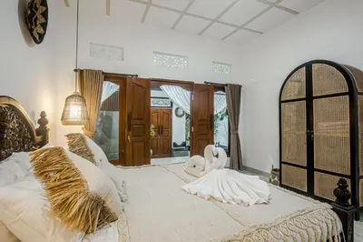 a bedroom with a bed with two swans on it at Villa Jasmine by JB VIllas in Seminyak