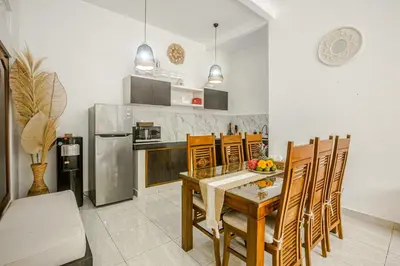 a kitchen with a table and chairs and a refrigerator at Villa Jasmine by JB VIllas in Seminyak