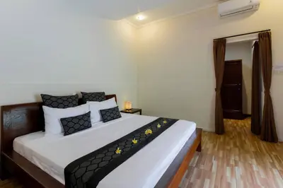 a bedroom with a bed with black and white pillows at Villa Tranquil Holiday Villa in Seminyak
