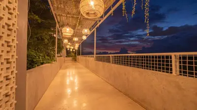a walkway with lights on the side of a building at Cozy Stay Bali by ARM Hospitality in Seminyak