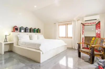 a white bedroom with a large bed and a chair at Luxurious&Spacious 4Br Villa in Seminyak in Seminyak