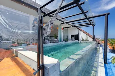 a house with a swimming pool and a hammock at Beautiful Penthouse w/ incredible views, pool, & cinema room! in Canggu
