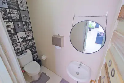 a bathroom with a mirror and a toilet and a sink at Beautiful Penthouse w/ incredible views, pool, & cinema room! in Canggu
