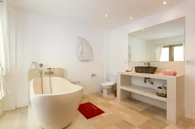a white bathroom with a tub and a toilet at Wonderful 4Br Villa in Seminyak in Seminyak