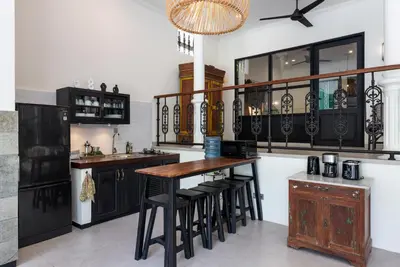 a kitchen with black cabinets and a wooden table at Villa Baruna Seminyak in Seminyak