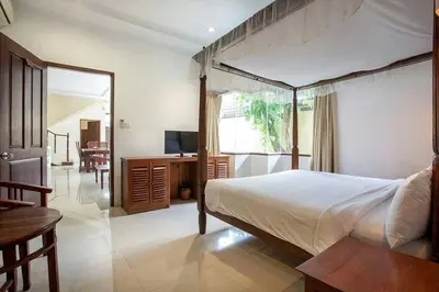 a bedroom with a bed and a desk and a television at Clasic Private Pool Villa in Seminyak in Seminyak