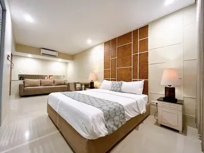 a bedroom with a large bed and a couch at Astana Residence in Seminyak