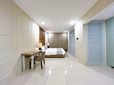 a bedroom with a bed and a desk and a table at Astana Residence in Seminyak
