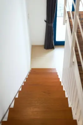a staircase in a room with wood floors and a window at The Blue Loft Seminyak free scooter in Seminyak